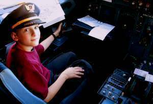 The pilot lets William wear his cap and sit in the cockpit. Fun!